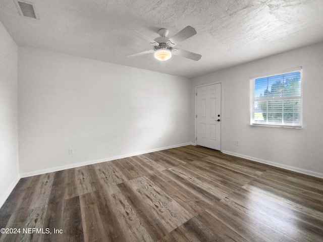 spare room featuring ceiling fan, a textured ceiling, and dark hardwood / wood-style floors