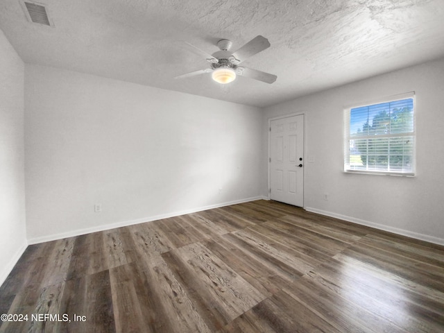 spare room with wood finished floors, baseboards, ceiling fan, and a textured ceiling