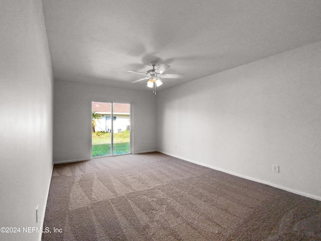 carpeted spare room featuring a ceiling fan and baseboards
