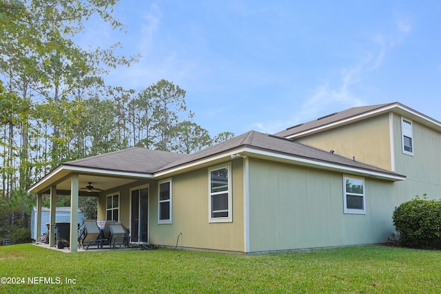 rear view of property featuring a patio, ceiling fan, and a yard