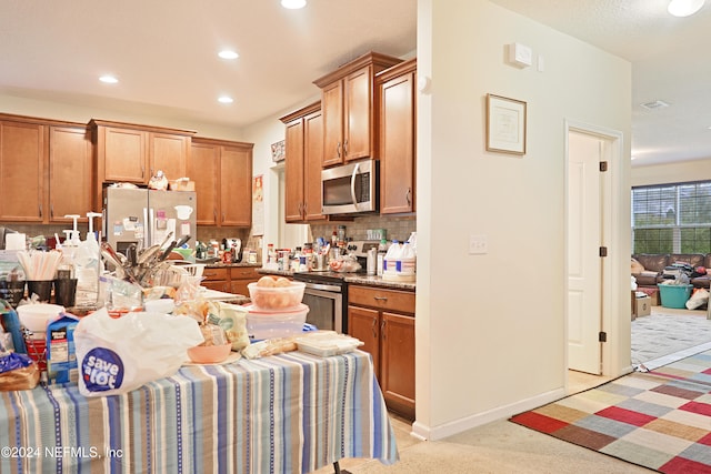 kitchen with stainless steel appliances, tasteful backsplash, and light colored carpet