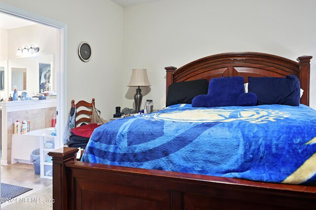 bedroom featuring light colored carpet and ensuite bathroom