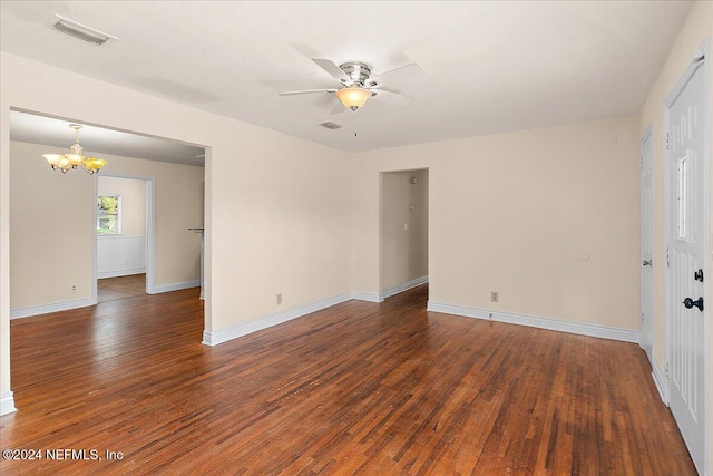 empty room featuring dark wood-type flooring and ceiling fan with notable chandelier