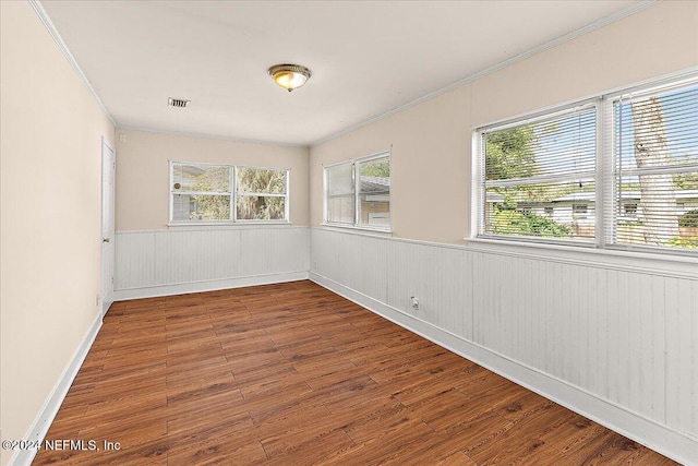 spare room featuring crown molding and hardwood / wood-style flooring