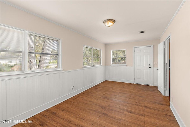 spare room with crown molding and hardwood / wood-style flooring