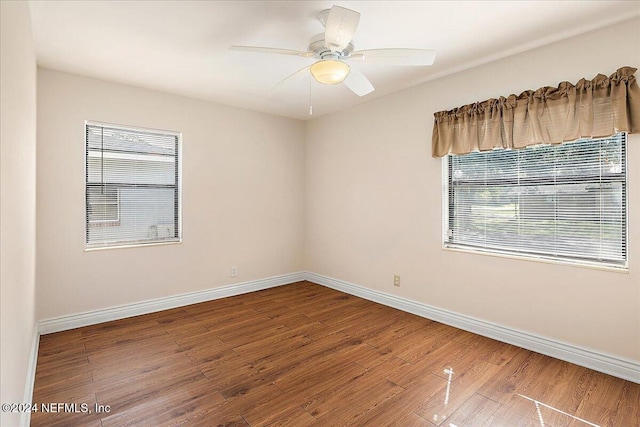 unfurnished room featuring a healthy amount of sunlight, hardwood / wood-style flooring, and ceiling fan