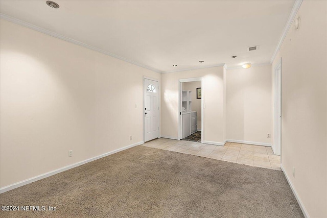 spare room featuring crown molding, light colored carpet, and separate washer and dryer