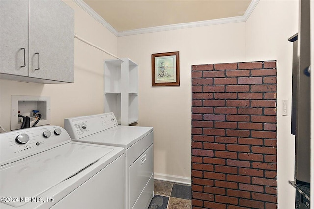 clothes washing area featuring crown molding, washing machine and dryer, and cabinets