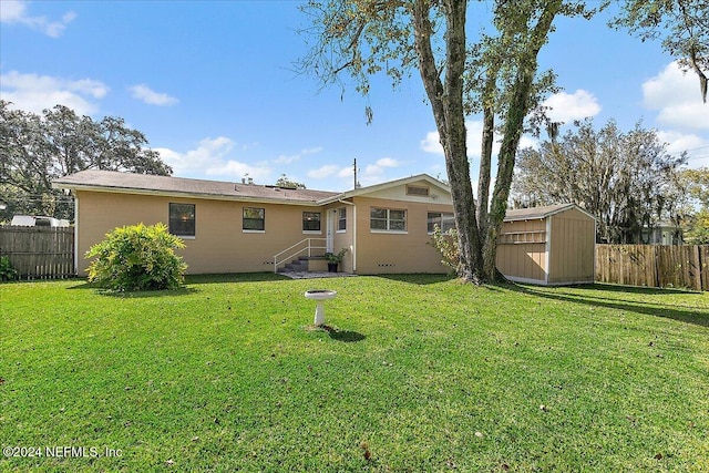 back of property featuring a storage unit and a yard