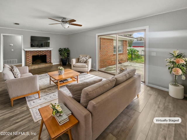 living room with wood-type flooring, a fireplace, and ceiling fan