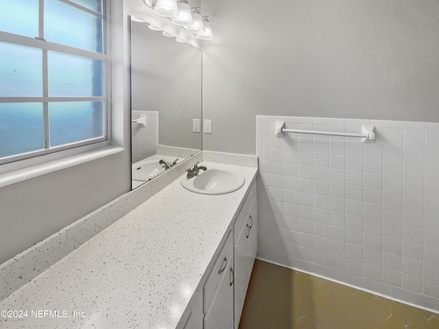 bathroom featuring vanity and tile walls