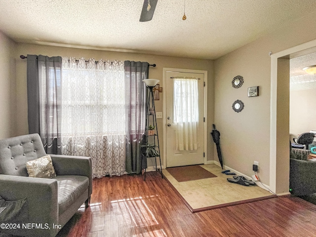 entrance foyer featuring hardwood / wood-style flooring, ceiling fan, and a textured ceiling