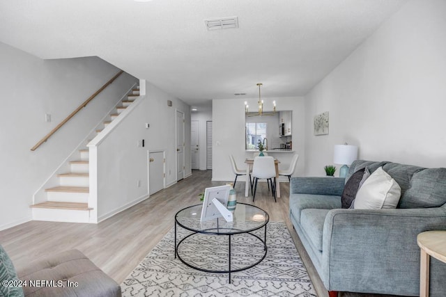 living room with a notable chandelier and light hardwood / wood-style floors