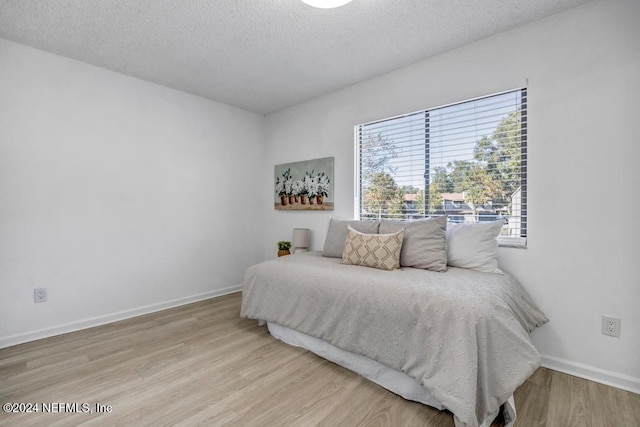 bedroom with wood-type flooring and a textured ceiling