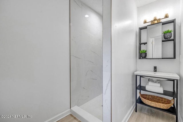 8300 Plaza Gate Ln Unit 1183, Jacksonville, FL 32217 - bathroom with wood finished floors, baseboards, a walk in shower, and a sink