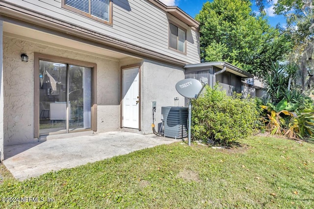 exterior space with a lawn, cooling unit, and a patio