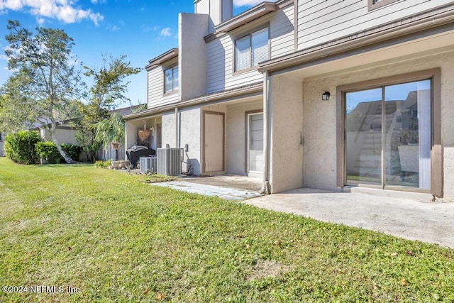 8300 Plaza Gate Ln Unit 1183, Jacksonville, FL 32217 - rear view of house featuring a yard, stucco siding, and central air condition unit