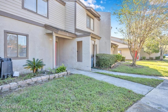 8300 Plaza Gate Ln Unit 1183, Jacksonville, FL 32217 - doorway to property featuring stucco siding and a yard