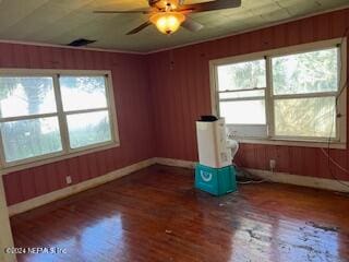 unfurnished room featuring dark wood-type flooring, ceiling fan, and a healthy amount of sunlight