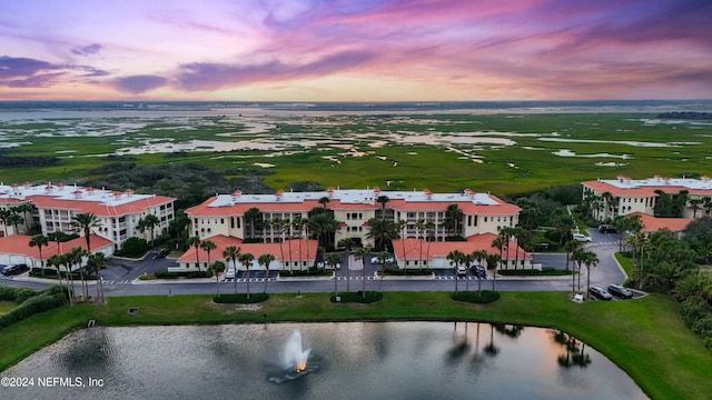 aerial view at dusk featuring a water view