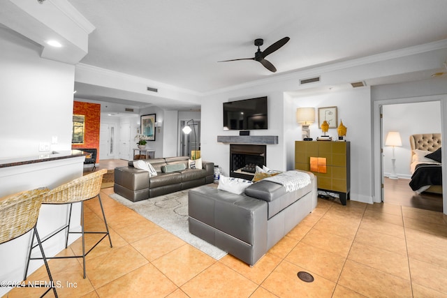 living room with crown molding, ceiling fan, and light tile patterned floors