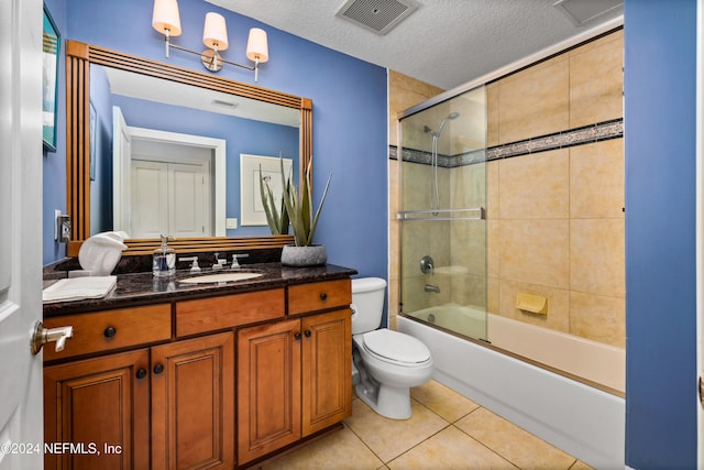 full bathroom with bath / shower combo with glass door, a textured ceiling, toilet, vanity, and tile patterned floors