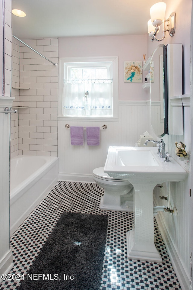 bathroom featuring tile patterned floors, tiled shower / bath, and toilet