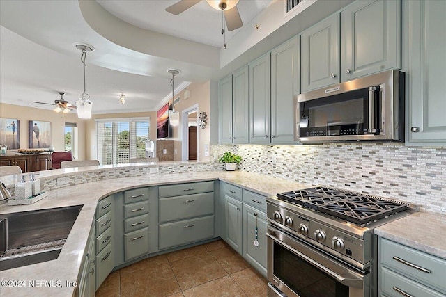 kitchen with decorative backsplash, sink, light tile patterned flooring, pendant lighting, and appliances with stainless steel finishes