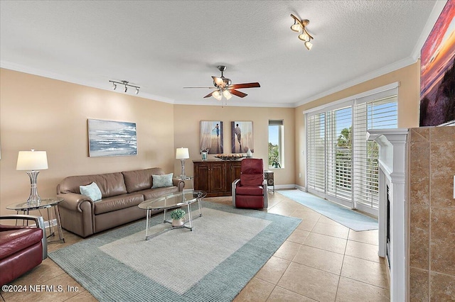 living room featuring ceiling fan, a textured ceiling, track lighting, and ornamental molding