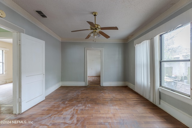 unfurnished room with a wealth of natural light, light hardwood / wood-style flooring, a textured ceiling, and ceiling fan