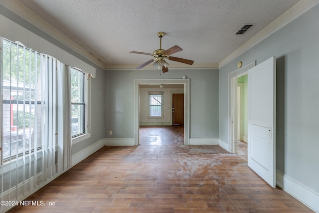 spare room with ceiling fan, hardwood / wood-style flooring, a textured ceiling, and crown molding