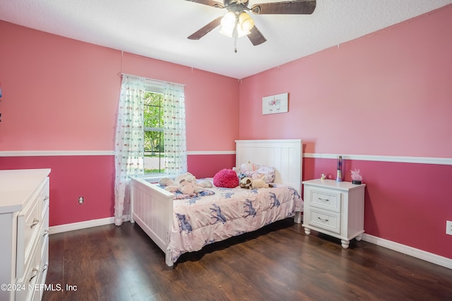 bedroom with dark wood-type flooring, ceiling fan, and a textured ceiling