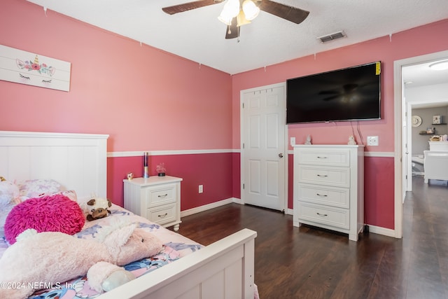 bedroom with dark hardwood / wood-style flooring, a textured ceiling, and ceiling fan