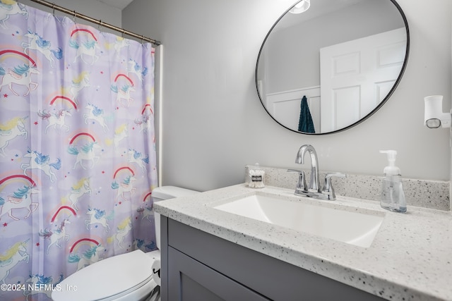 bathroom featuring toilet, vanity, and a shower with shower curtain