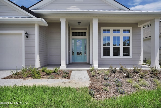 doorway to property featuring covered porch and a garage