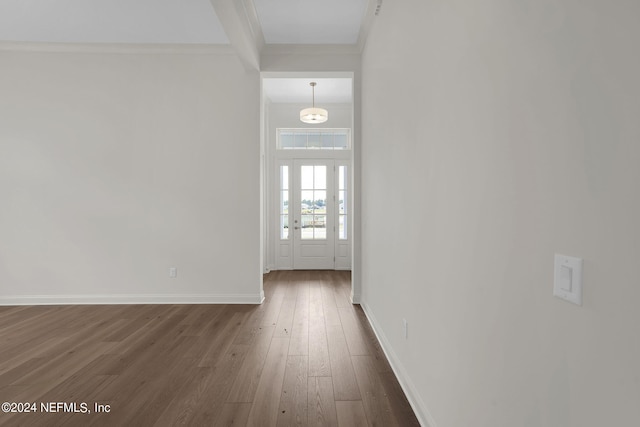 foyer entrance with crown molding and dark hardwood / wood-style floors