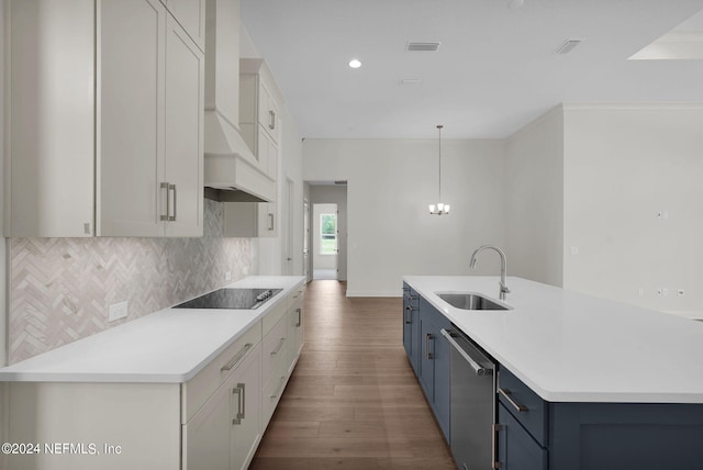 kitchen featuring sink, dark hardwood / wood-style flooring, hanging light fixtures, stainless steel dishwasher, and blue cabinetry