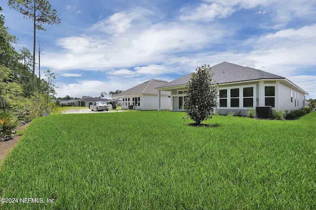 back of house with a yard and central AC unit