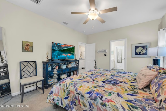 bedroom featuring ceiling fan, ensuite bathroom, and light carpet