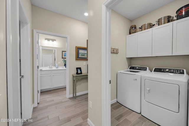 clothes washing area featuring cabinets, washer and clothes dryer, and sink