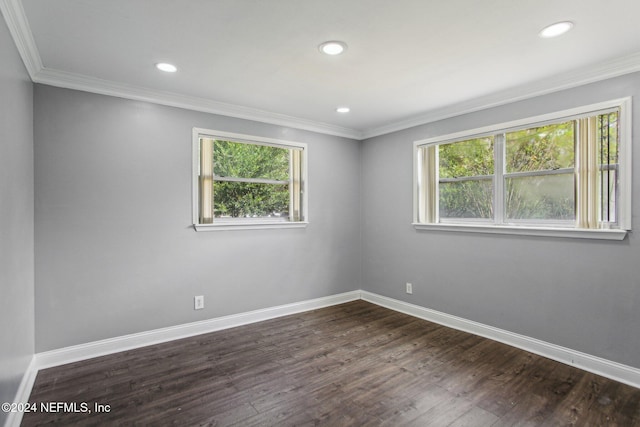 empty room with ornamental molding and dark hardwood / wood-style floors