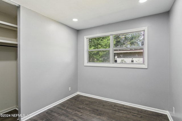 unfurnished bedroom featuring a closet and dark hardwood / wood-style flooring