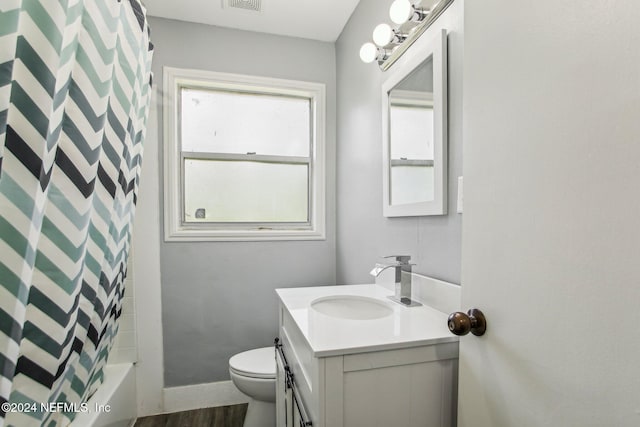 full bathroom with vanity, hardwood / wood-style flooring, toilet, and shower / tub combo