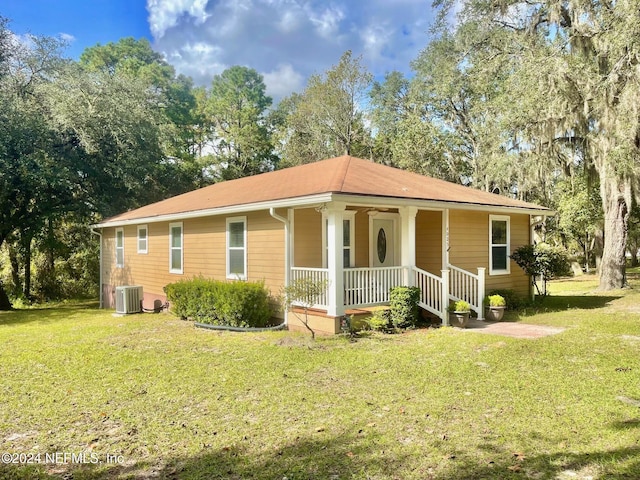 view of front of home featuring covered porch, a front yard, and cooling unit