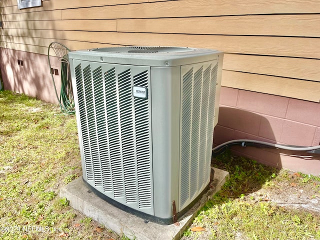 details featuring cooling unit and wood walls