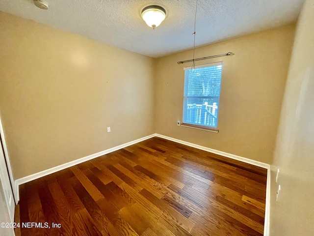 unfurnished room featuring hardwood / wood-style floors and a textured ceiling