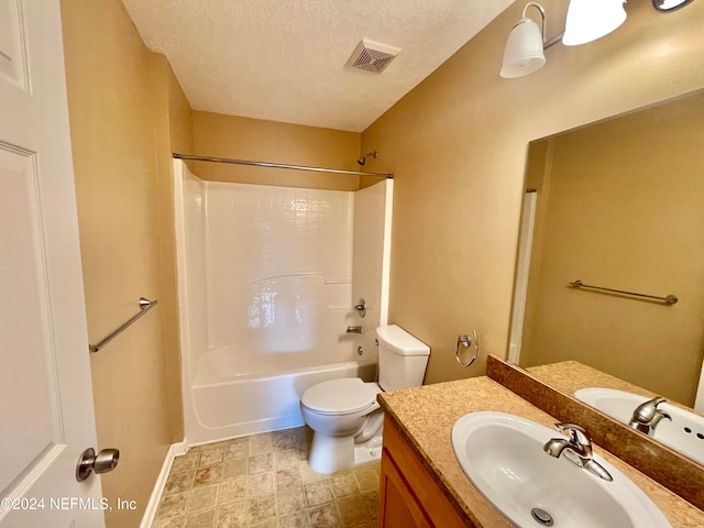 full bathroom featuring vanity, toilet, a textured ceiling, and shower / washtub combination