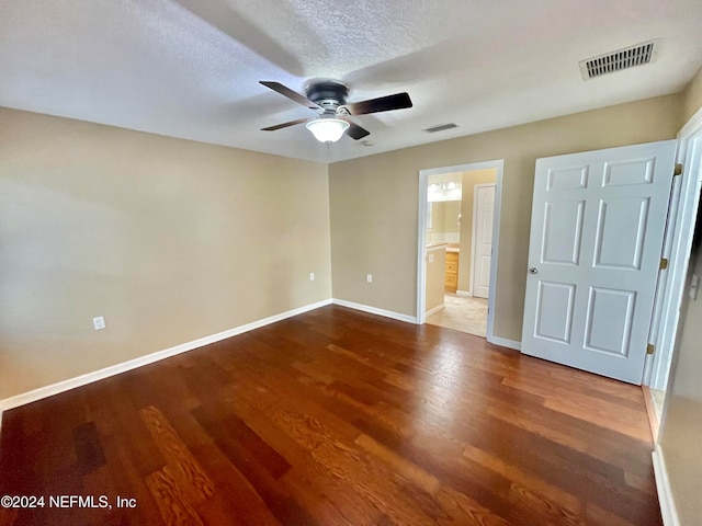 unfurnished bedroom featuring connected bathroom, a textured ceiling, wood-type flooring, and ceiling fan