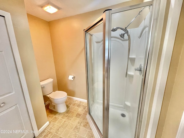 bathroom with a shower with door and toilet