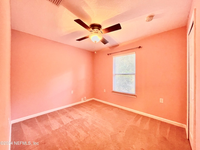 empty room with ceiling fan, carpet flooring, and a textured ceiling